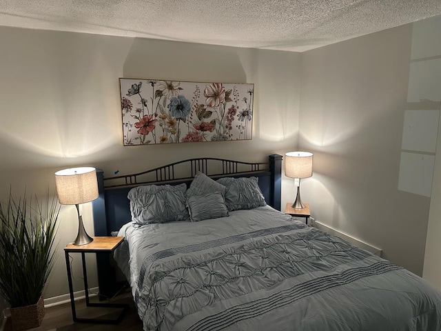 bedroom with hardwood / wood-style floors and a textured ceiling