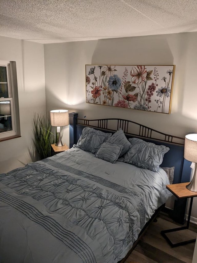 bedroom with hardwood / wood-style floors and a textured ceiling