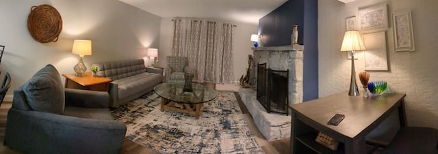 living room with a stone fireplace and hardwood / wood-style flooring