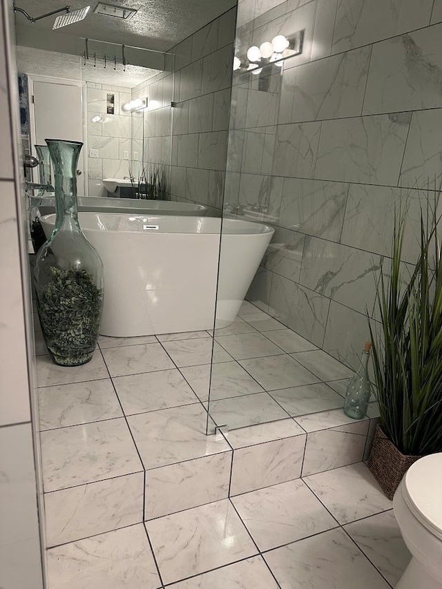 bathroom featuring a bath, toilet, and tile walls