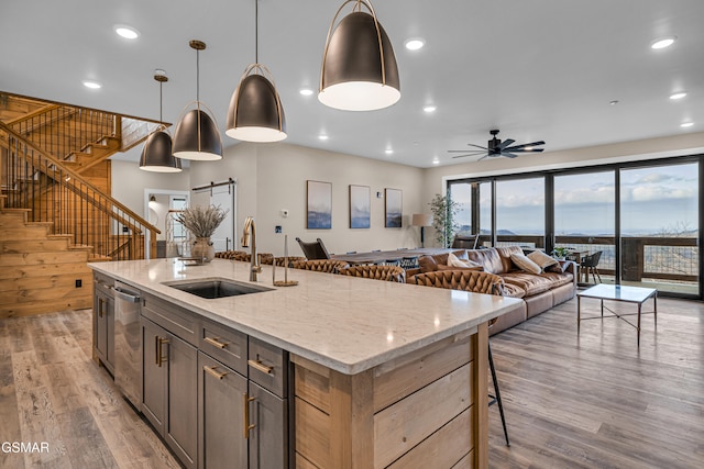 1505 Misty Ct, Sevierville, TN 37862 - kitchen with stainless steel dishwasher, light wood finished floors, ceiling fan, a kitchen bar, and light stone counters