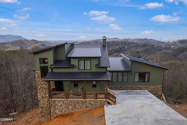 1505 Misty Ct, Sevierville, TN 37862 - view of front facade with a mountain view, a porch, a chimney, and stone siding