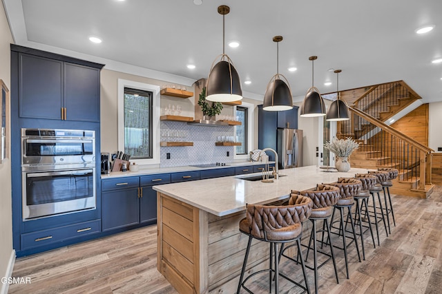 1505 Misty Ct, Sevierville, TN 37862 - kitchen featuring stainless steel appliances, blue cabinets, light wood-style floors, a breakfast bar area, and recessed lighting