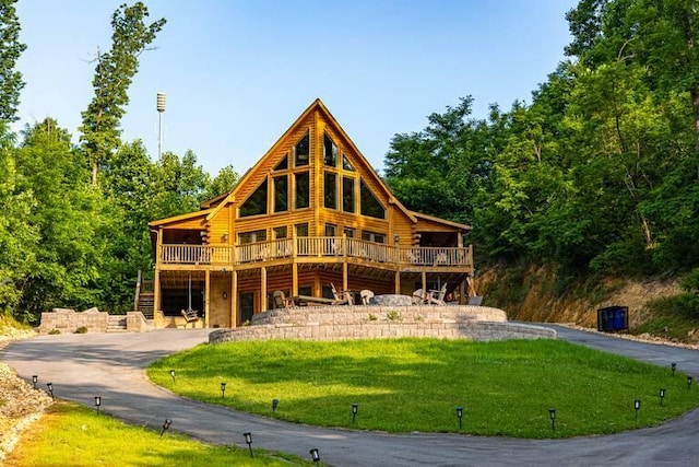 rear view of property featuring a lawn and a wooden deck