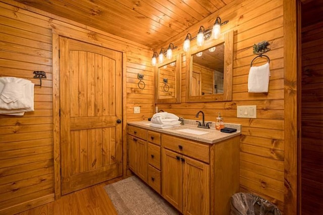 bathroom featuring wood walls, vanity, wooden ceiling, and hardwood / wood-style flooring