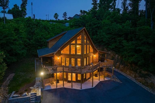 rear view of property featuring a patio area and a wooden deck