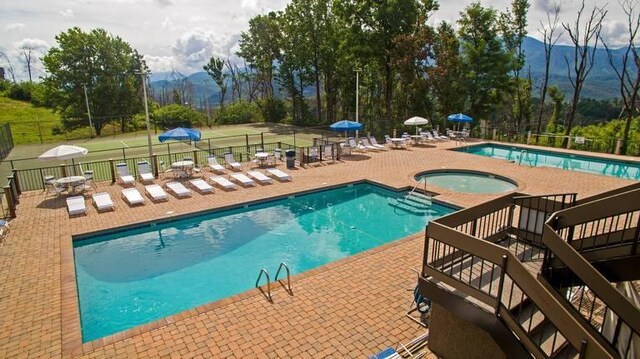 view of swimming pool featuring a mountain view, a community hot tub, and a patio