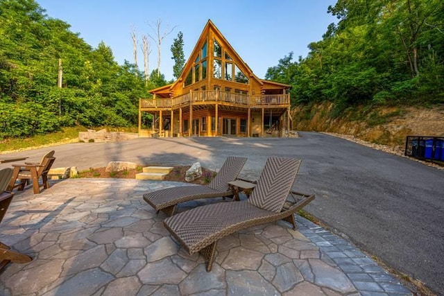 back of property featuring a patio area and a deck