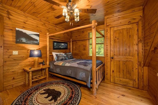 bedroom with wood walls, ceiling fan, light hardwood / wood-style floors, and wooden ceiling