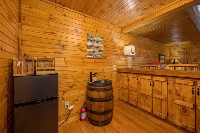 bar with refrigerator and light hardwood / wood-style flooring