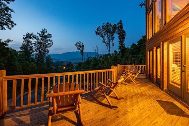 deck at dusk featuring a mountain view