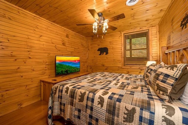 bedroom with ceiling fan, wooden ceiling, and wood walls