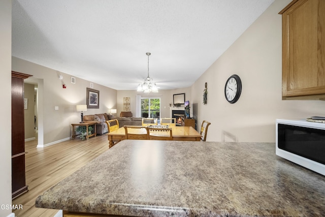 205 Ogle Dr Unit 614, Pigeon Forge, TN 37863 - kitchen with white microwave, light wood-style flooring, ceiling fan, open floor plan, and baseboards