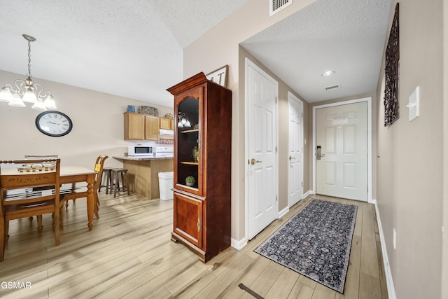 205 Ogle Dr Unit 614, Pigeon Forge, TN 37863 - entryway featuring a chandelier, light wood-style flooring, a textured ceiling, and baseboards