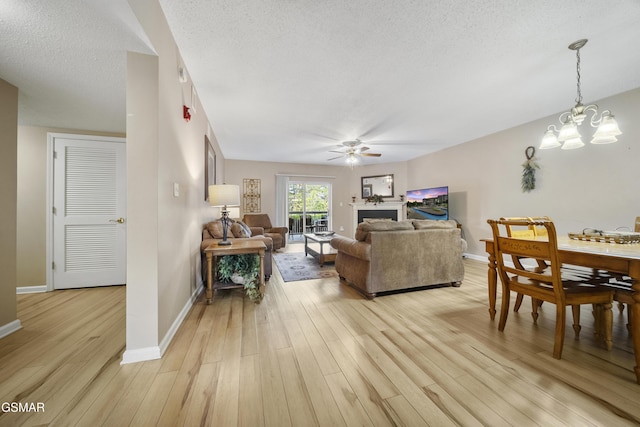 205 Ogle Dr Unit 614, Pigeon Forge, TN 37863 - living room with ceiling fan, a chandelier, light wood-type flooring, a textured ceiling, and baseboards