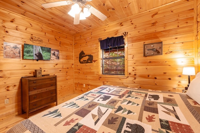 bedroom featuring a ceiling fan, wooden ceiling, wooden walls, and wood finished floors