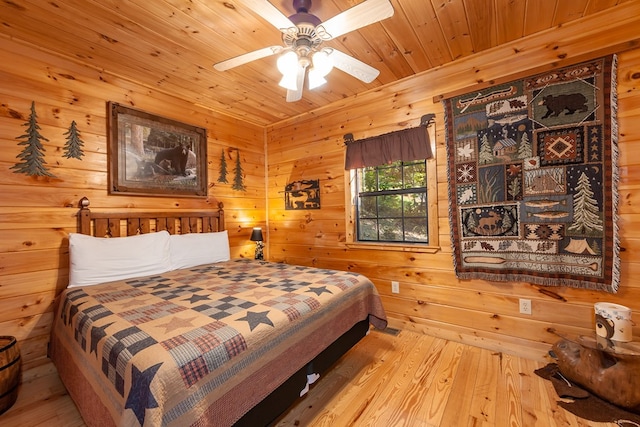 bedroom with wood walls, wooden ceiling, wood finished floors, and a ceiling fan