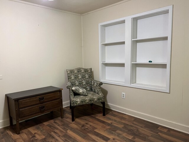 living area with dark hardwood / wood-style floors, built in features, and crown molding