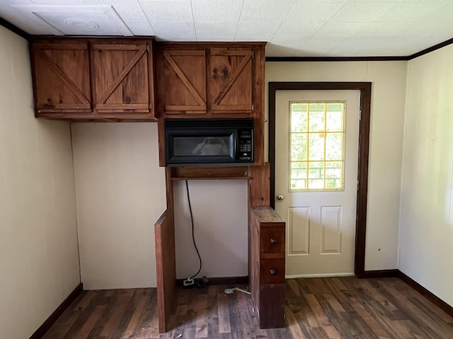 kitchen featuring crown molding and dark wood-type flooring