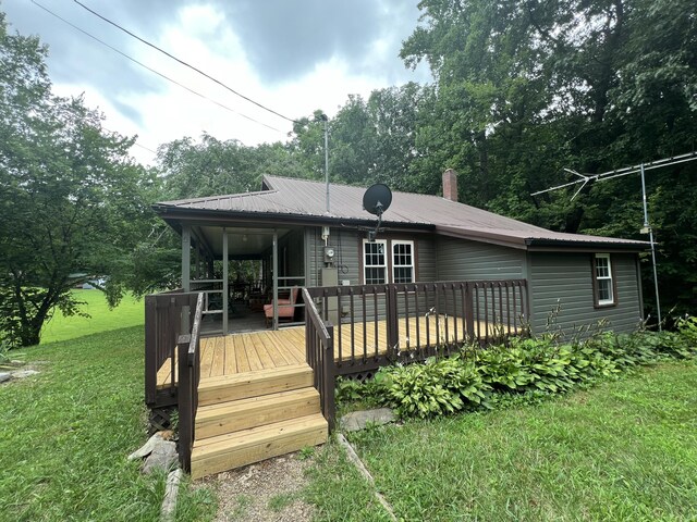 back of property with a wooden deck and a yard