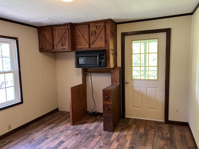 doorway to outside featuring crown molding and dark wood-type flooring