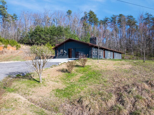 4323 Boogertown Rd, Sevierville, TN 37876 - view of home's exterior with driveway, a chimney, and a lawn