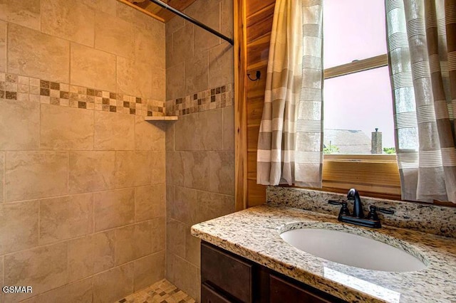 bathroom featuring a tile shower and vanity