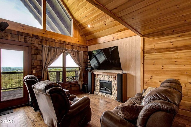 living area with lofted ceiling with beams, a stone fireplace, wooden walls, wood ceiling, and wood-type flooring