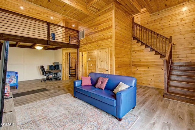 living room with wood finished floors, wood ceiling, beamed ceiling, and stairs