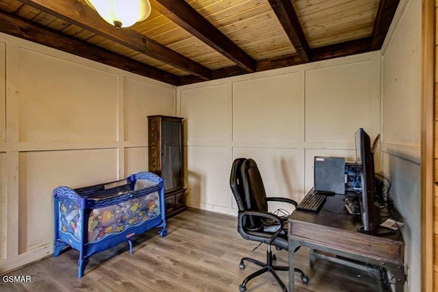 office with wooden ceiling, a decorative wall, beamed ceiling, and wood finished floors