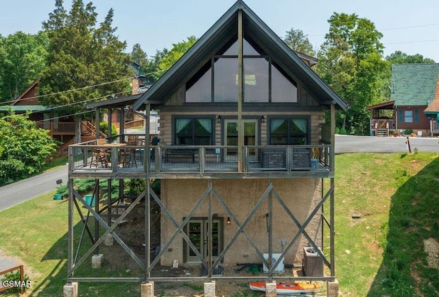 exterior space featuring a wooden deck, log exterior, and a front yard