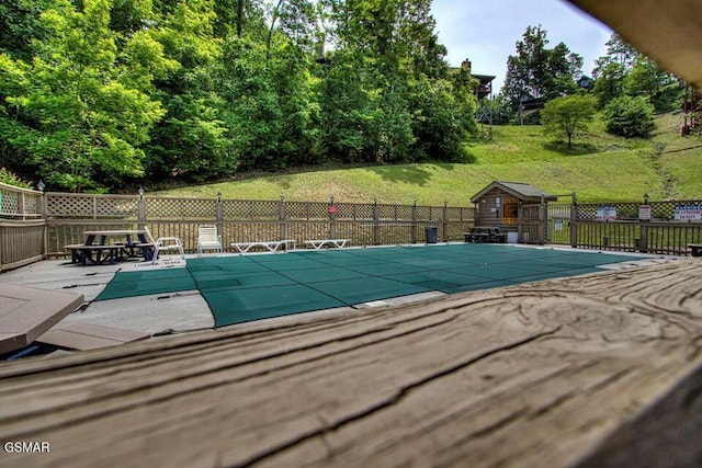 view of swimming pool featuring a yard, a patio area, fence, and a fenced in pool