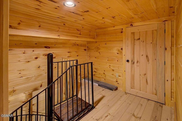 additional living space featuring a sauna, wooden ceiling, hardwood / wood-style flooring, and wooden walls