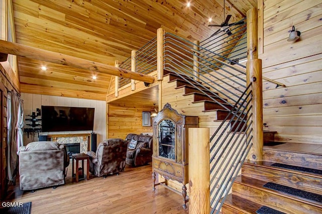 stairway with wooden ceiling, a fireplace, wooden walls, and wood finished floors