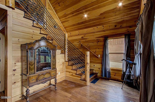 interior space with lofted ceiling, wood ceiling, wood walls, and wood finished floors