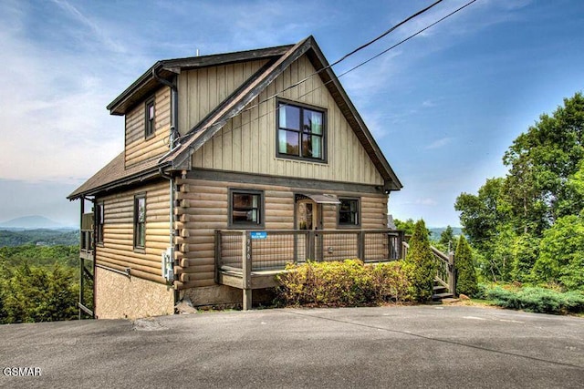 log-style house featuring covered porch and log siding