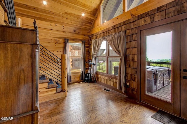 entryway with a healthy amount of sunlight, visible vents, and wooden walls