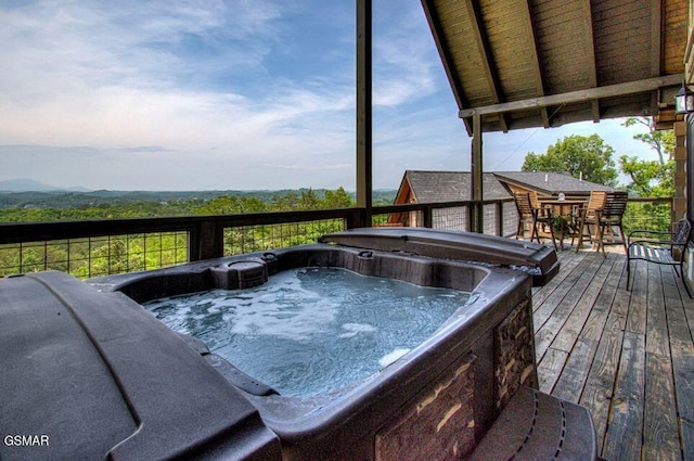 deck with a hot tub and outdoor dining space