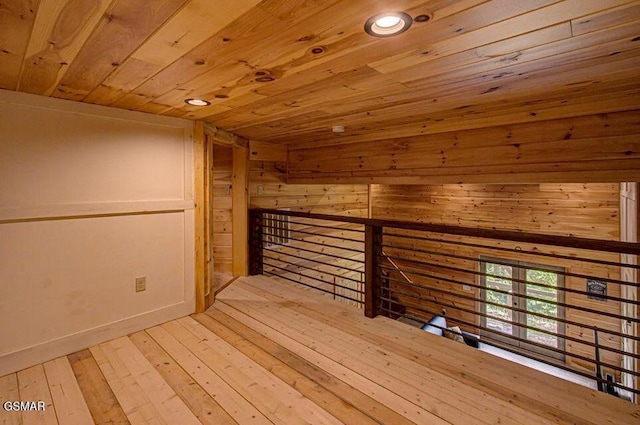 additional living space with wood ceiling, a sauna, and light wood finished floors