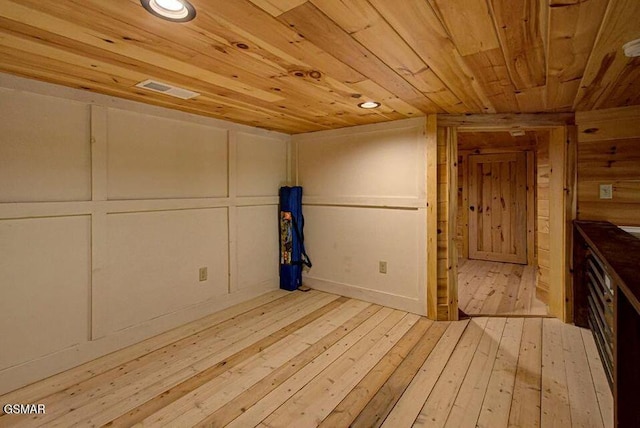 empty room with recessed lighting, a decorative wall, wooden ceiling, and light wood-style floors