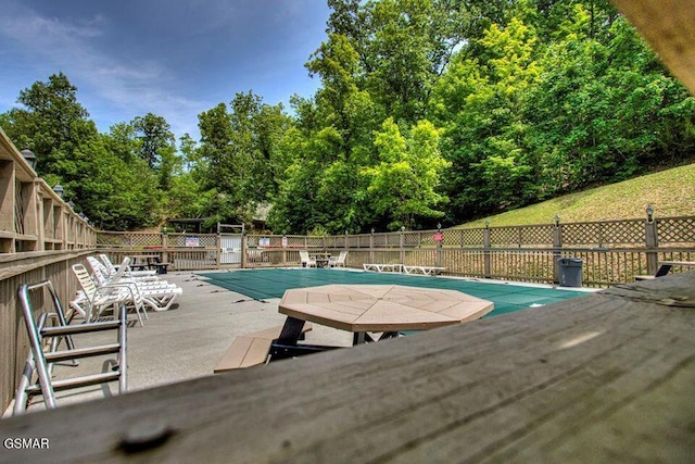 community pool featuring a patio area and fence