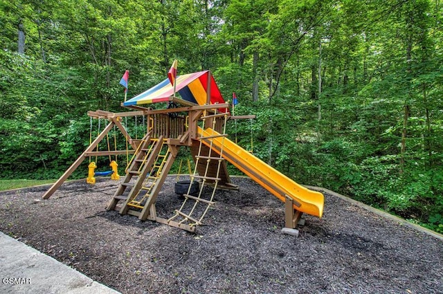 view of jungle gym featuring a view of trees