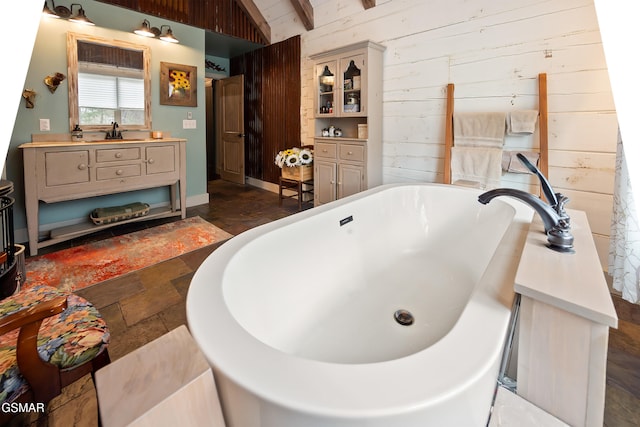 4115 Mae Ln, Sevierville, TN 37862 - bathroom featuring a freestanding bath, wood walls, vanity, and stone finish floor