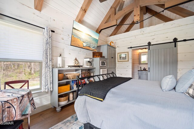 4115 Mae Ln, Sevierville, TN 37862 - bedroom with wooden walls, beam ceiling, a barn door, and wood finished floors