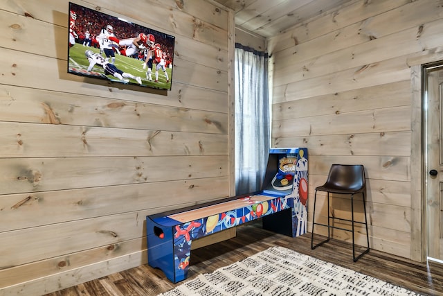 bedroom with wood-type flooring and wooden walls