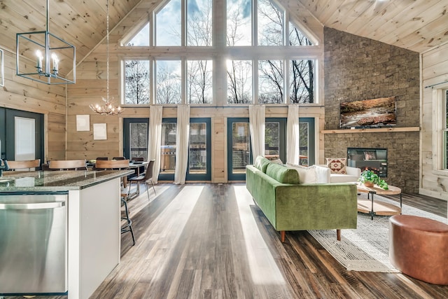 living room with a notable chandelier, hardwood / wood-style floors, wood ceiling, high vaulted ceiling, and wood walls