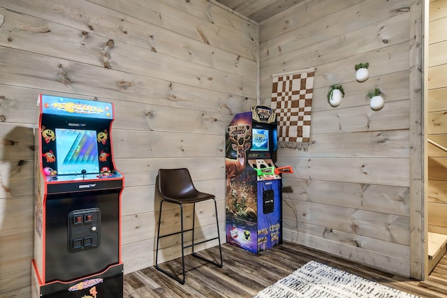 game room with hardwood / wood-style floors and wooden walls