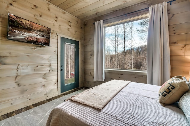 bedroom featuring wooden ceiling, hardwood / wood-style floors, and wood walls