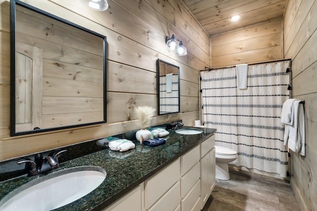 bathroom with wood ceiling, vanity, toilet, wood walls, and a shower with shower curtain