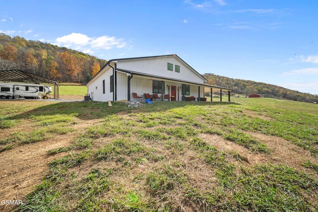 view of front of property featuring a mountain view, a front lawn, and cooling unit